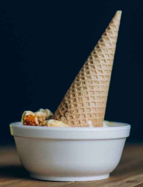 An ice cream cone upside down in a dish