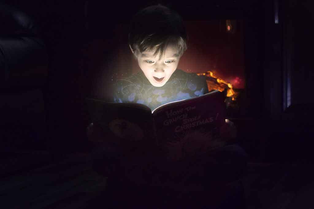 Little boy happily surprised by by what he's reading.